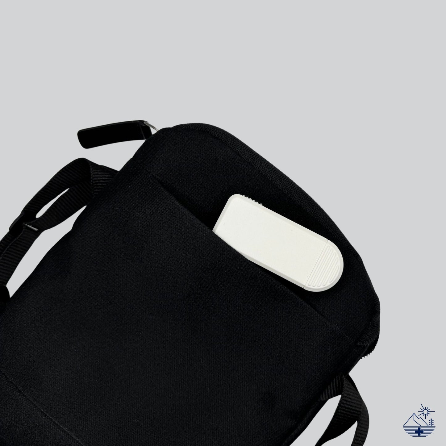 Compact 3-Compartment Pill Organizer (Monochrome White) partially tucked into a travel pouch. Ideal portable medication case for short trips.