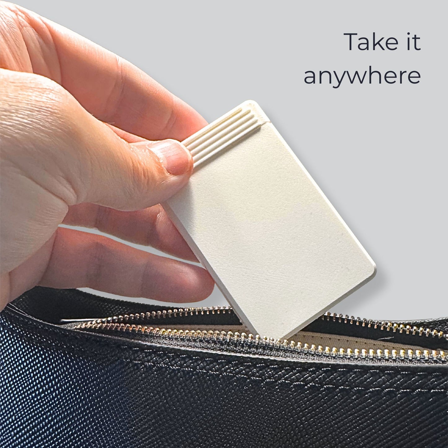 Compact pill organizer being placed in a bag. Swiss-made travel pill case by Biinii Design for daily carry.