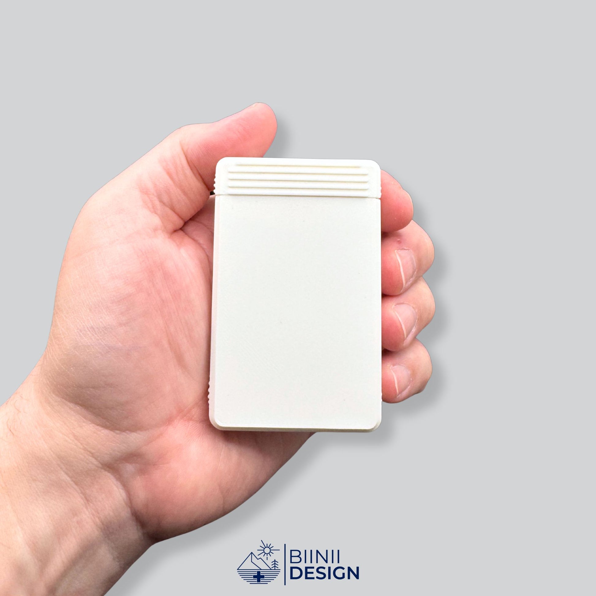 Hand holding the compact 7-day pill organizer to show scale. From Biinii Design’s 49-color line, travel-ready and minimalist design.
