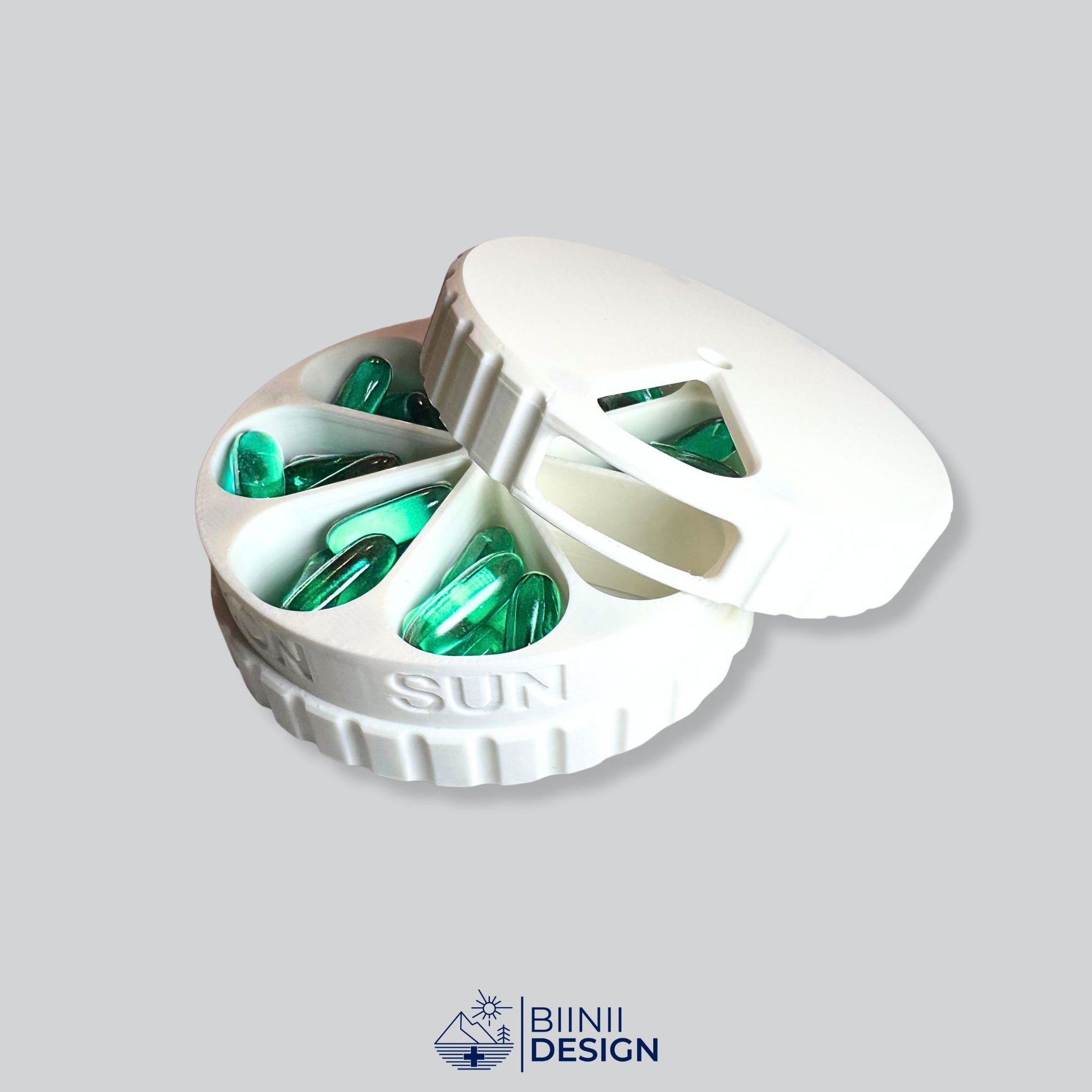 Half-open 7-day pill organizer showing all daily compartments filled with pills, supplements and liquid-tabs. Safe hidden magnetic closure, by Biinii Design.