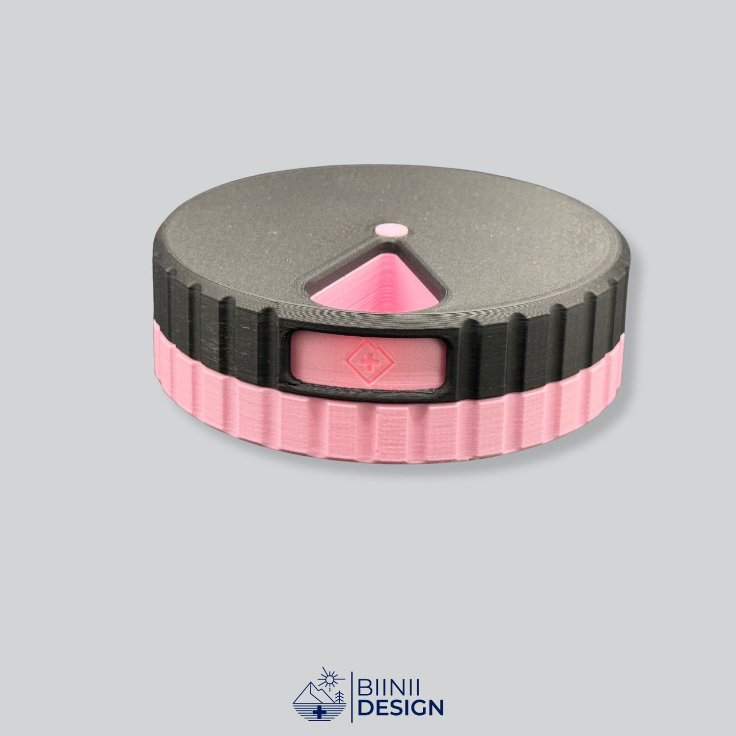 Black lid with pink base; round magnetic pill organizer.