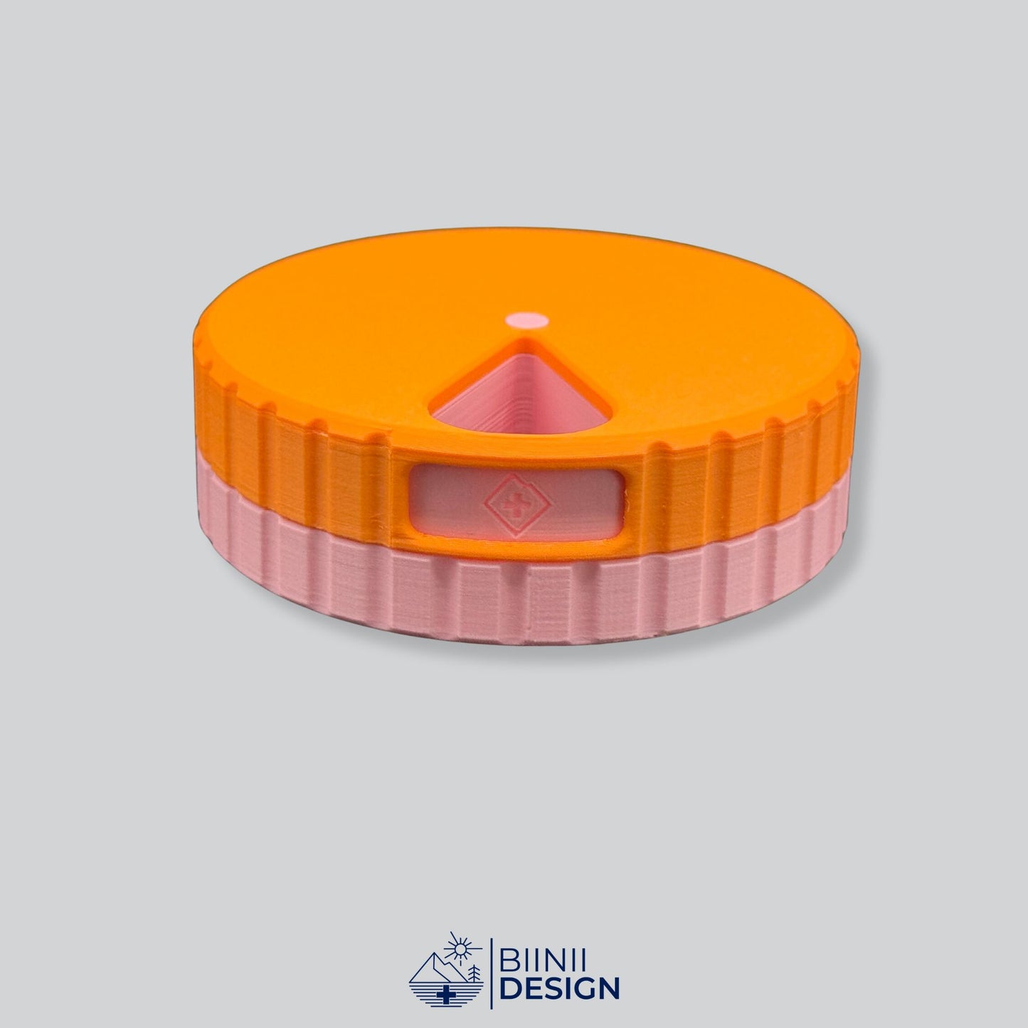 Orange lid with pink base; round magnetic pill organizer.