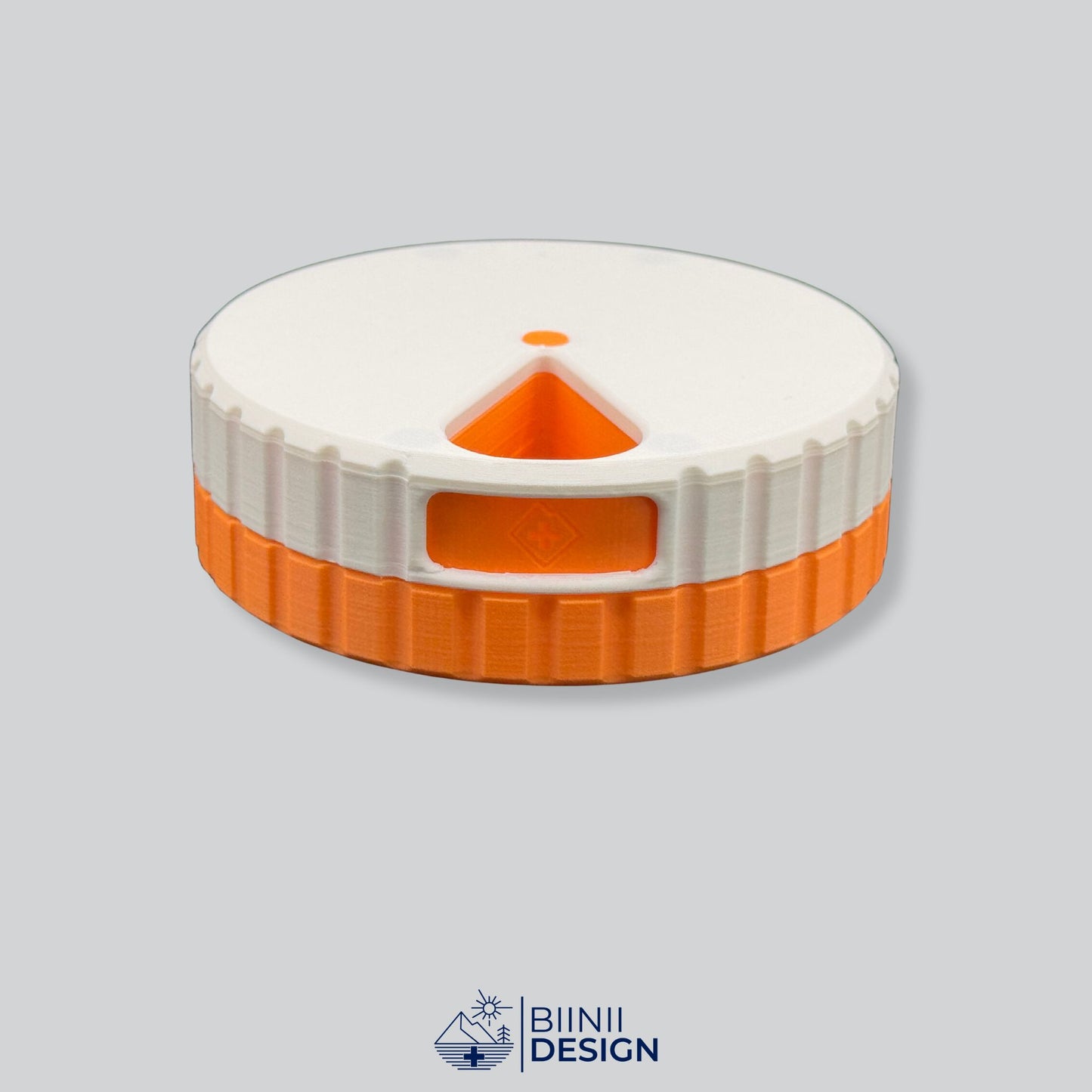 White lid with orange base; round magnetic pill organizer.