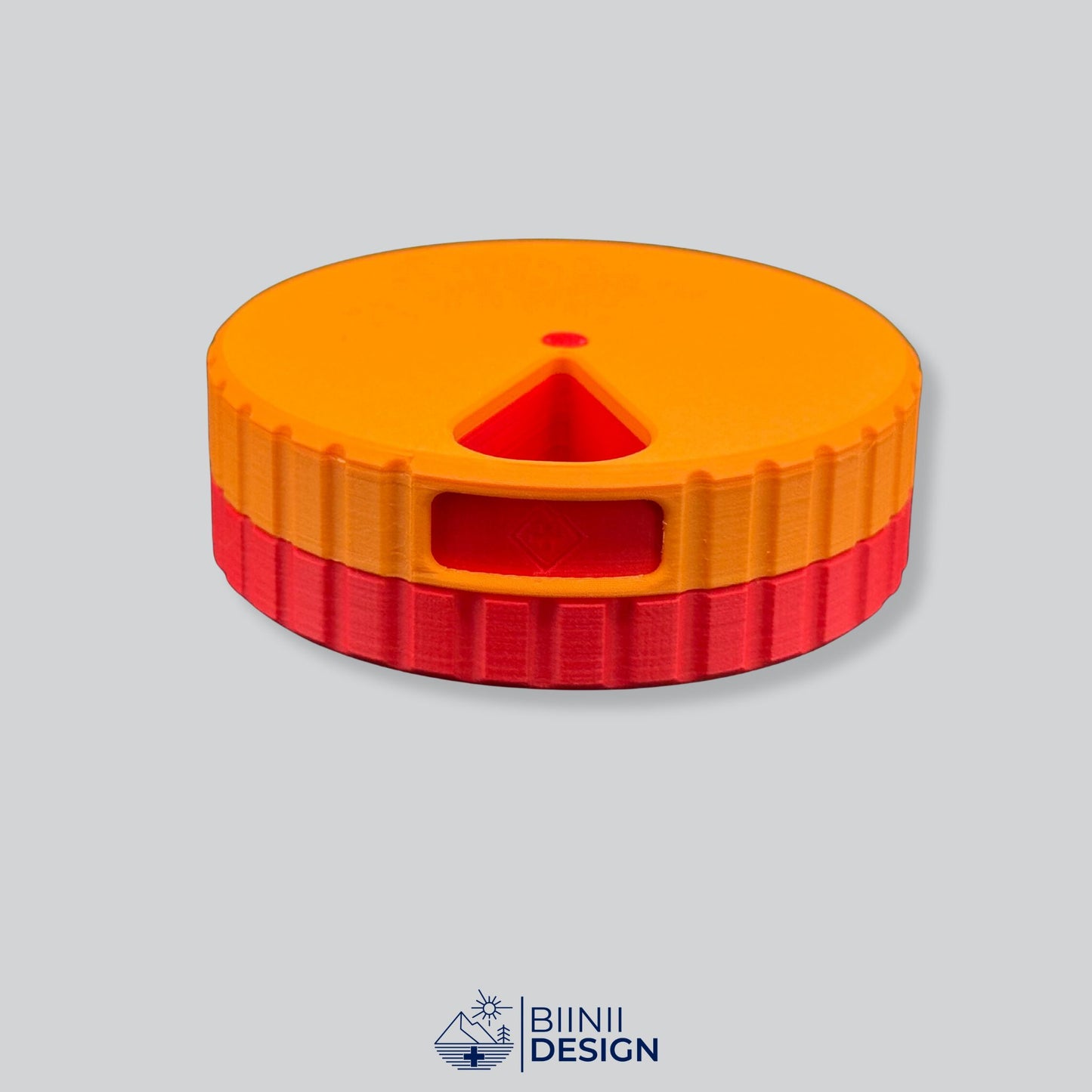 Orange lid contrasting with the red base on the bold round magnetic 7-day pill case.