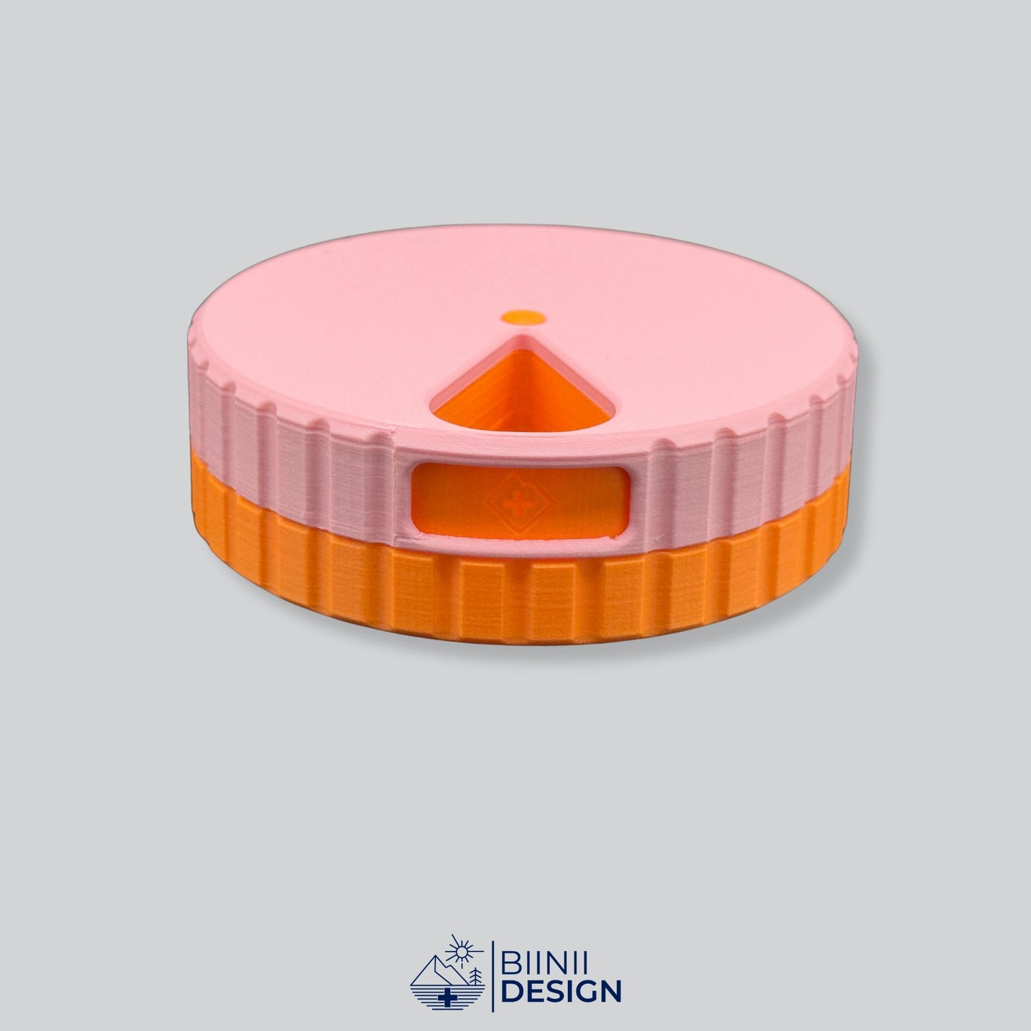 Pink lid contrasting with the orange base on the round magnetic pill organizer.