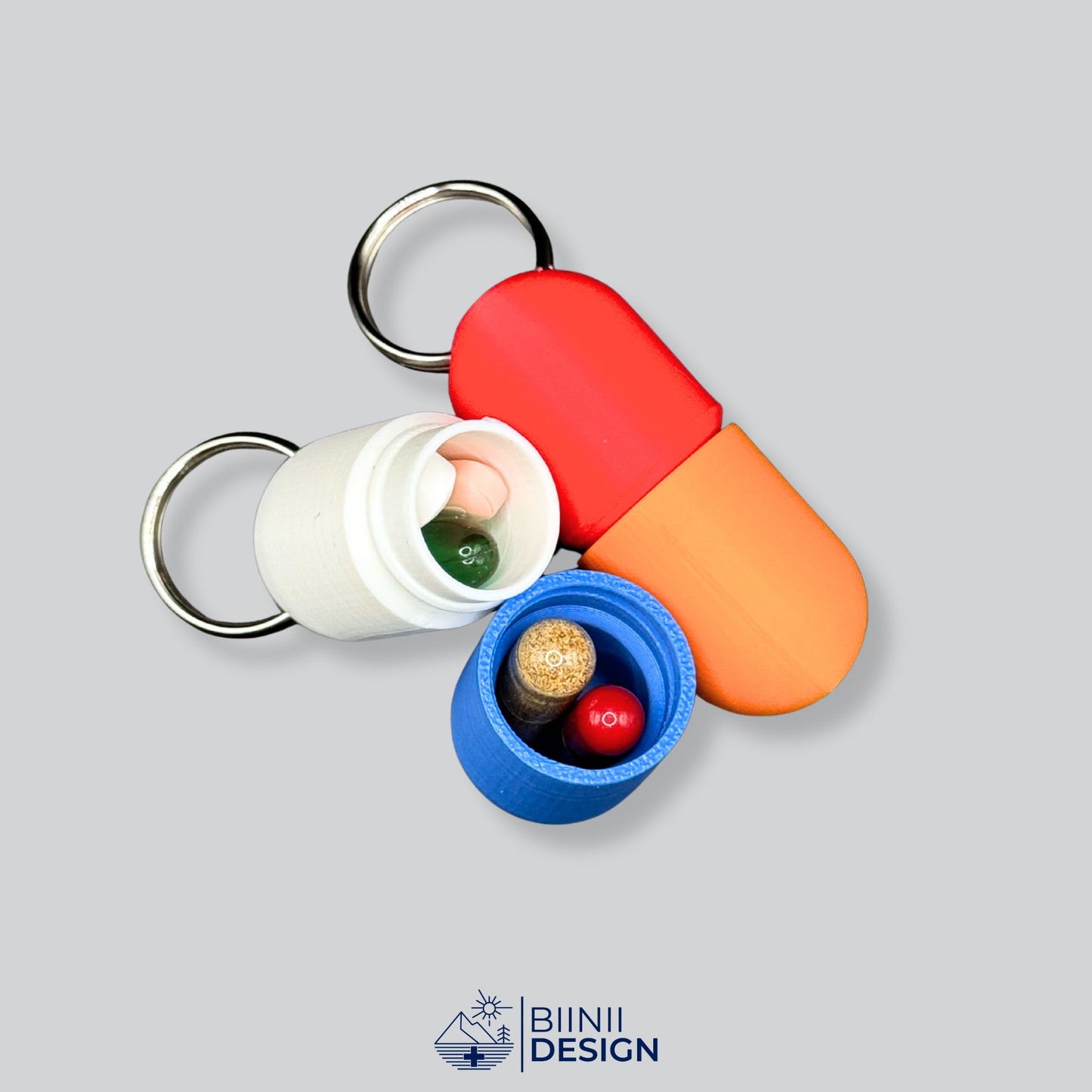 Open large keyring pillbox in white and blue with colorful pills inside, Swiss-made compact daily travel organizer.
Keywords: pillbox, pill holder, keyring pillbox, travel