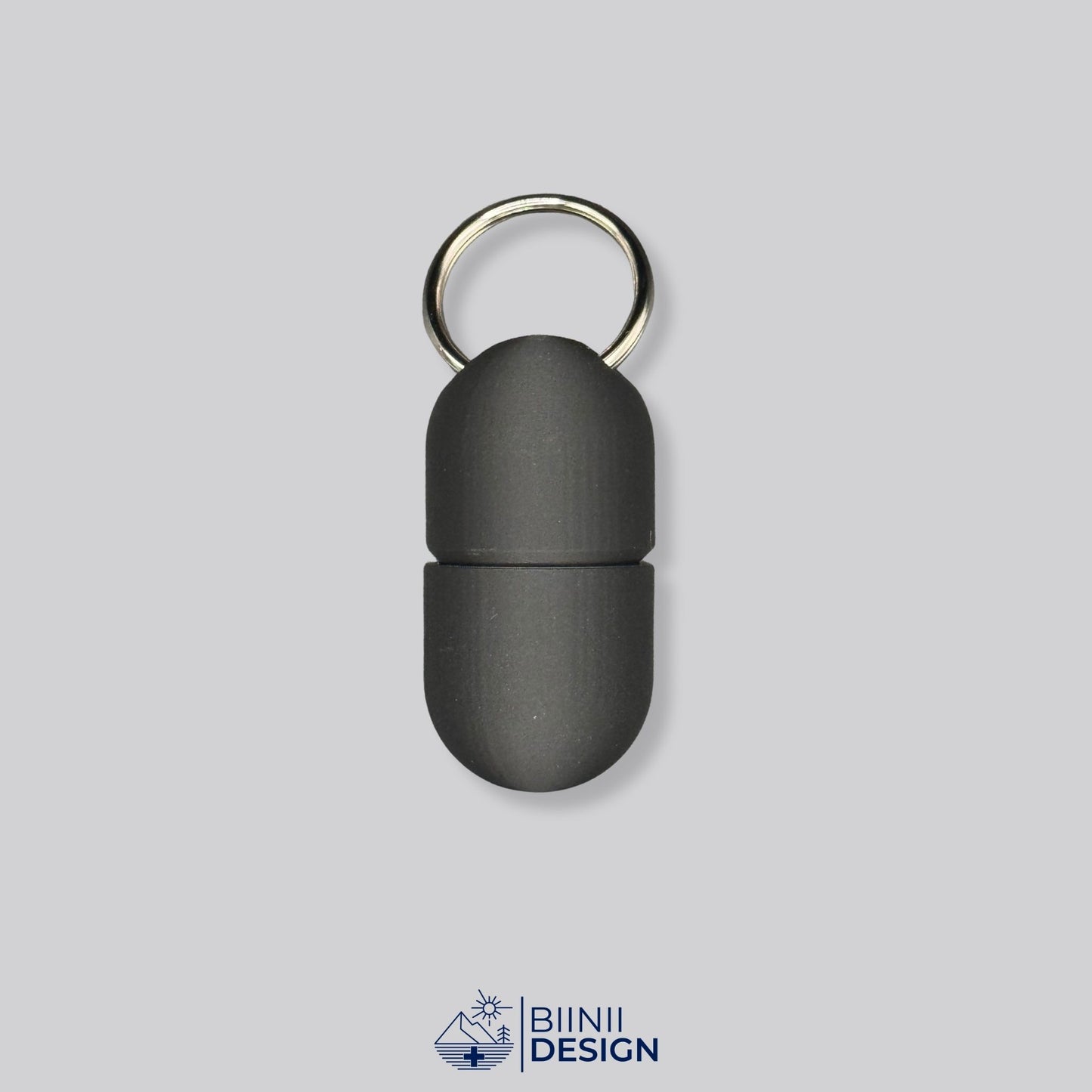 All-black capsule pillbox with screw-top and keyring. A sleek, minimalist container for pills, vitamins, or Lactaid on the go.
Keywords: black pillbox, discreet supplement case, minimalist pill holder