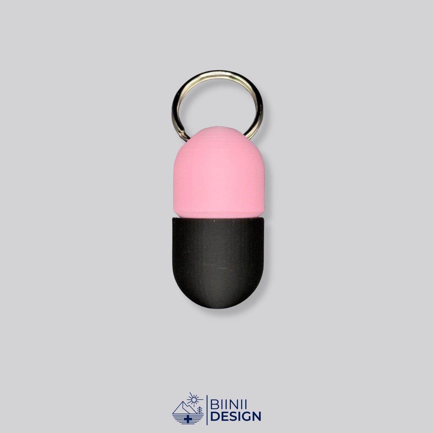 Pink and black keyring pillbox with capsule design. A bold yet practical way to carry supplements or Lactaid discreetly.
Keywords: black-pink pill container, keychain med box, compact pill holder