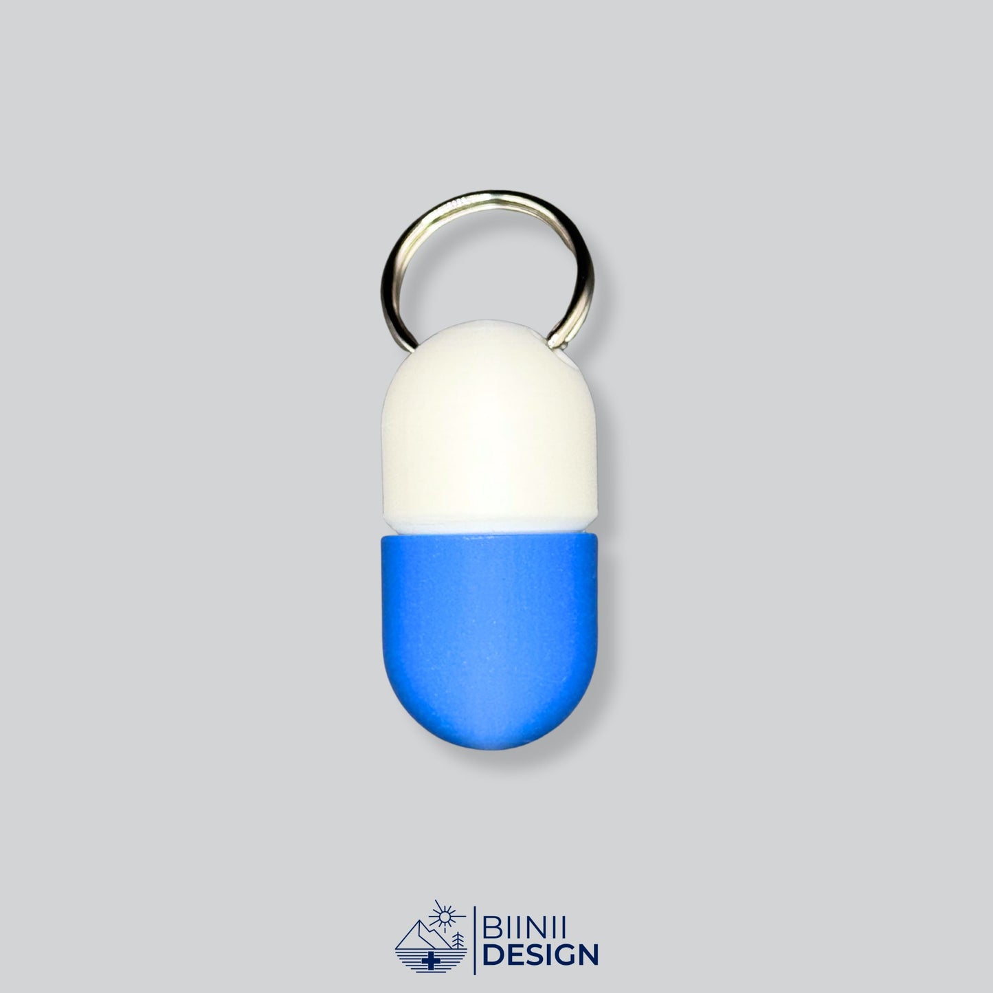 White and blue capsule pillbox on keyring. Sleek travel companion for your daily pills, supplements, or antihistamines.
Keywords: keychain pill holder, compact med case, travel pill container