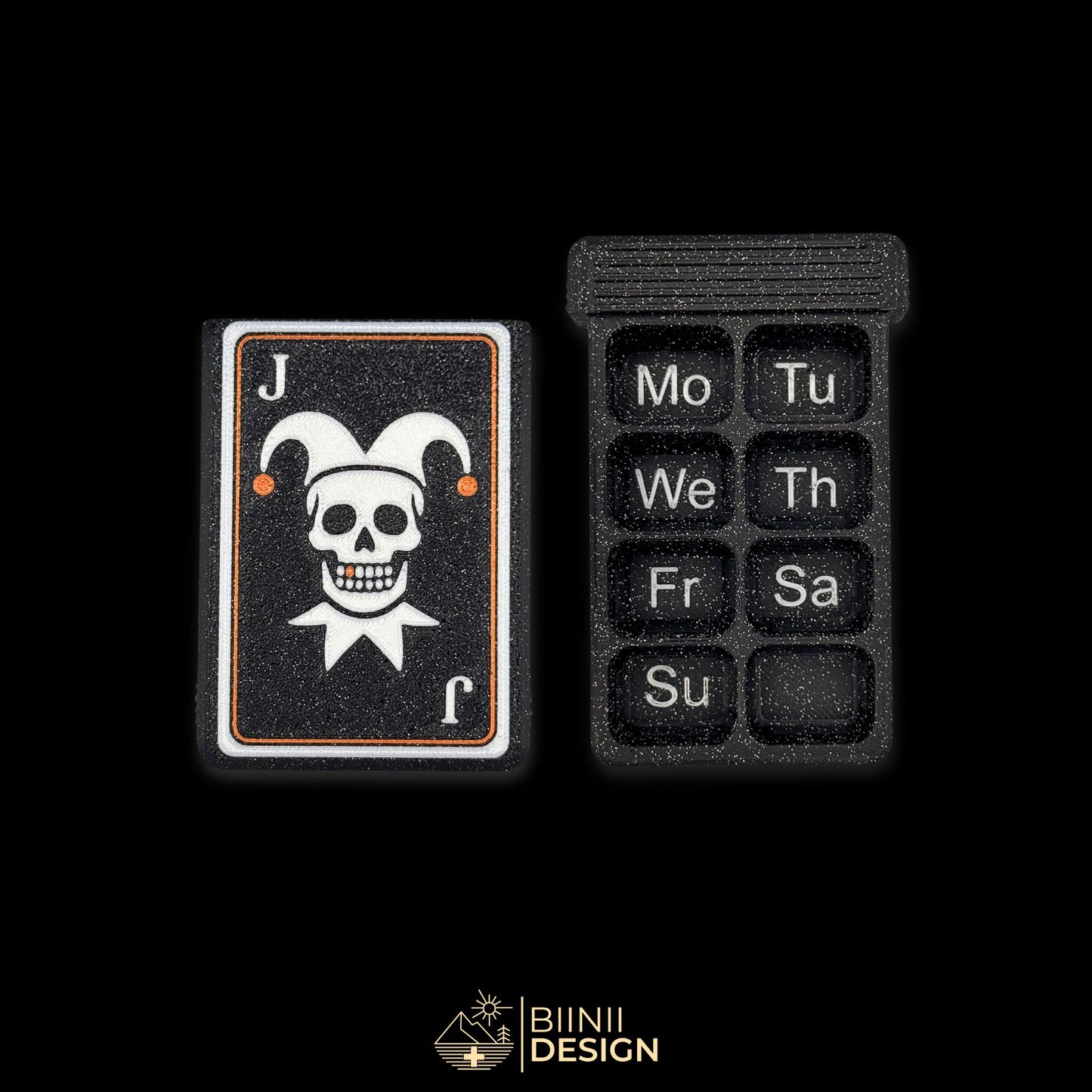 Weekly Joker pill box starting Monday, matte galaxy black, skull playing card lid with copper tooth, for daily meds, vitamins, and supplements. Keywords: weekly pill organizer Monday start, gothic pill case, travel pill box, vitamin organizer