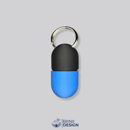 Zweifarbige Compact-Pillendose für den Schlüsselanhänger, Oberteil in Schwarz und Unterteil in Blau.