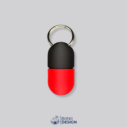Zweifarbige Compact-Pillendose für den Schlüsselanhänger, Oberteil in Schwarz und Unterteil in Rot.