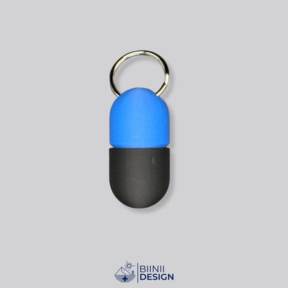 Zweifarbige Compact-Pillendose für den Schlüsselanhänger, Oberteil in Blau und Unterteil in Schwarz.