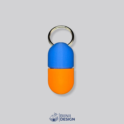 Zweifarbige Compact-Pillendose für den Schlüsselanhänger, Oberteil in Blau und Unterteil in Orange.