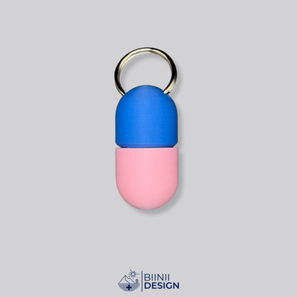 Zweifarbige Compact-Pillendose für den Schlüsselanhänger, Oberteil in Blau und Unterteil in Rosa.