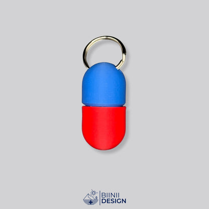 Zweifarbige Compact-Pillendose für den Schlüsselanhänger, Oberteil in Blau und Unterteil in Rot.