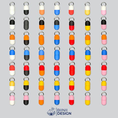 Illustration aller 49 ein- und zweifarbigen Farbkombinationen der Compact-Pillendose für den Schlüsselanhänger.