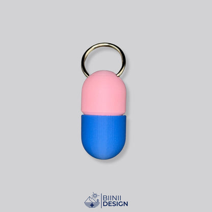 Zweifarbige Compact-Pillendose für den Schlüsselanhänger, Oberteil in Rosa und Unterteil in Blau.