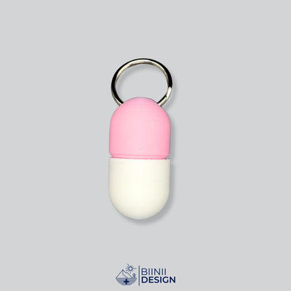 Zweifarbige Compact-Pillendose für den Schlüsselanhänger, Oberteil in Rosa und Unterteil in Weiß.