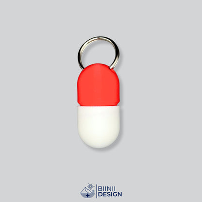 Zweifarbige Compact-Pillendose für den Schlüsselanhänger, Oberteil in Rot und Unterteil in Weiß.