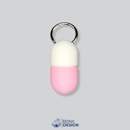 Zweifarbige Compact-Pillendose für den Schlüsselanhänger, Oberteil in Weiß und Unterteil in Rosa.