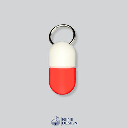 Zweifarbige Compact-Pillendose für den Schlüsselanhänger, Oberteil in Weiß und Unterteil in Rot.