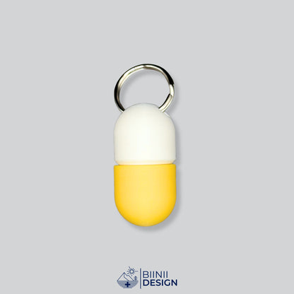Zweifarbige Compact-Pillendose für den Schlüsselanhänger, Oberteil in Weiß und Unterteil in Gelb.