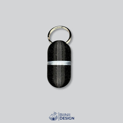 Pilulier porte-clés Deluxe Compact en galaxy black avec un accent argenté à la jonction.
