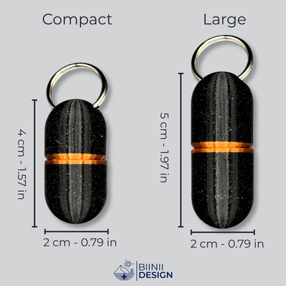 Piluliers porte-clés Deluxe Compact et Large en galaxy black à accents cuivrés, côte à côte, dimensions en cm et en pouces.