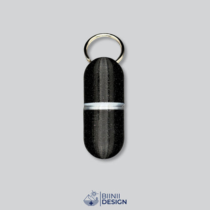 Pilulier porte-clés Deluxe Large en galaxy black avec un accent argenté à la jonction.