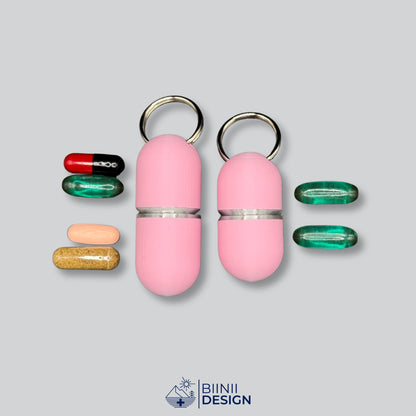 Kapazitätsvergleich der rosa Deluxe-Pillendose mit Silber-Akzenten: das Large-Modell fasst 4 Kapseln und Tabletten, das Compact-Modell 2 große Softgels.