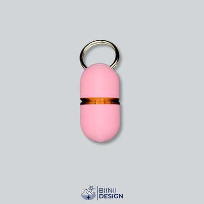Compact-Deluxe-Pillendose für den Schlüsselanhänger in zartem Rosa mit Kupfer-Akzent am Übergang.