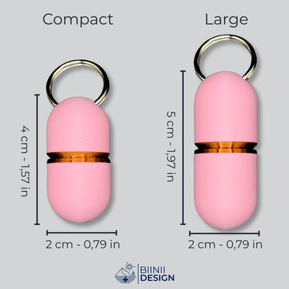 Compact- und Large-Deluxe-Pillendosen in zartem Rosa mit Kupfer-Akzenten nebeneinander, Maße in cm und Zoll.