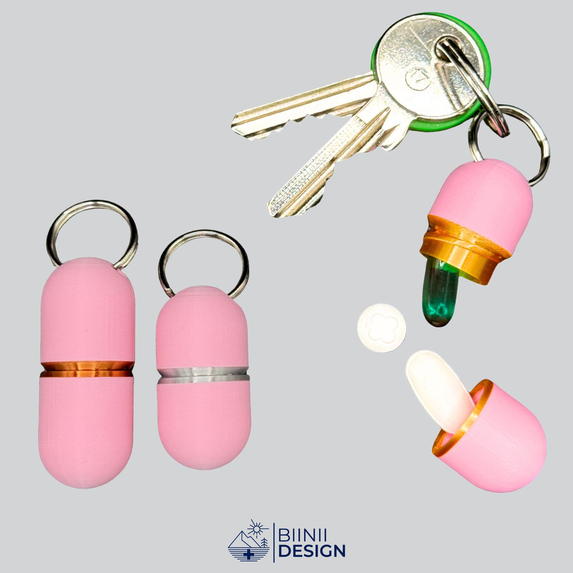 Offene Deluxe-Pillendose in zartem Rosa an Schlüsseln, ein Softgel oben, eine weiße längliche Tablette unten, daneben Compact in Silber und Large in Kupfer.