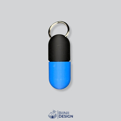 Zweifarbige Large-Pillendose für den Schlüsselanhänger, Oberteil in Schwarz und Unterteil in Blau.