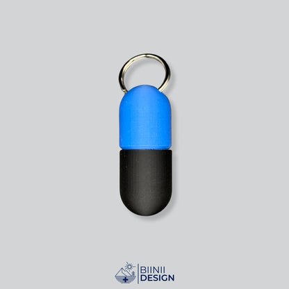 Zweifarbige Large-Pillendose für den Schlüsselanhänger, Oberteil in Blau und Unterteil in Schwarz.