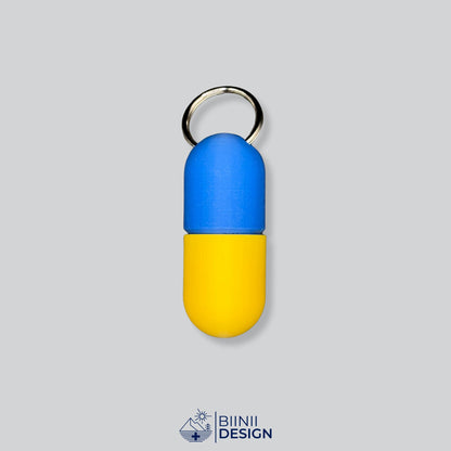 Zweifarbige Large-Pillendose für den Schlüsselanhänger, Oberteil in Blau und Unterteil in Gelb.