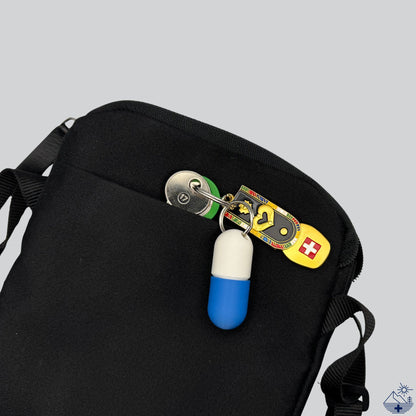Weiß-blaue Large-Pillendose für den Schlüsselanhänger am Schlüsselring mit Schlüsseln, verstaut in einer kleinen Alltagstasche.
