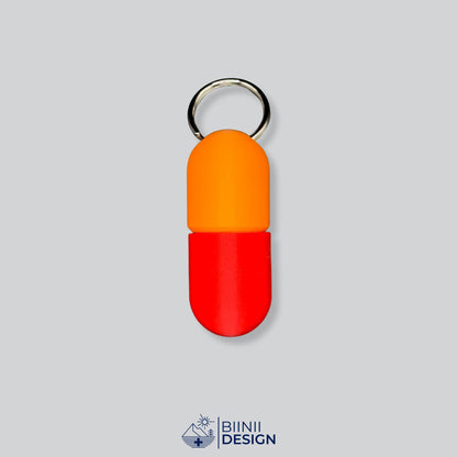 Zweifarbige Large-Pillendose für den Schlüsselanhänger, Oberteil in Orange und Unterteil in Rot.