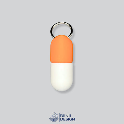Zweifarbige Large-Pillendose für den Schlüsselanhänger, Oberteil in Orange und Unterteil in Weiß.