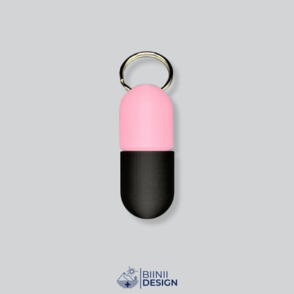 Zweifarbige Large-Pillendose für den Schlüsselanhänger, Oberteil in Rosa und Unterteil in Schwarz.