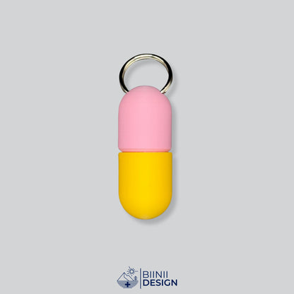 Zweifarbige Large-Pillendose für den Schlüsselanhänger, Oberteil in Rosa und Unterteil in Gelb.