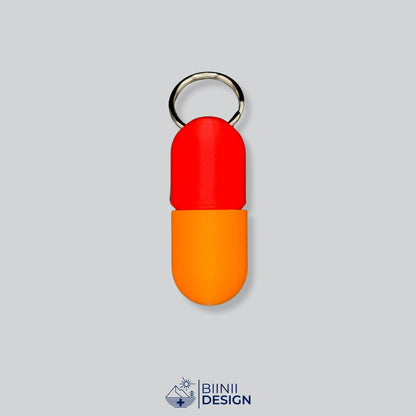Zweifarbige Large-Pillendose für den Schlüsselanhänger, Oberteil in Rot und Unterteil in Orange.
