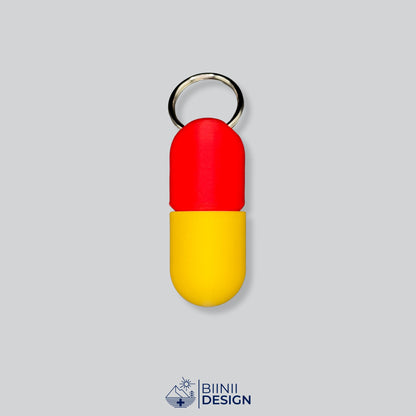Zweifarbige Large-Pillendose für den Schlüsselanhänger, Oberteil in Rot und Unterteil in Gelb.