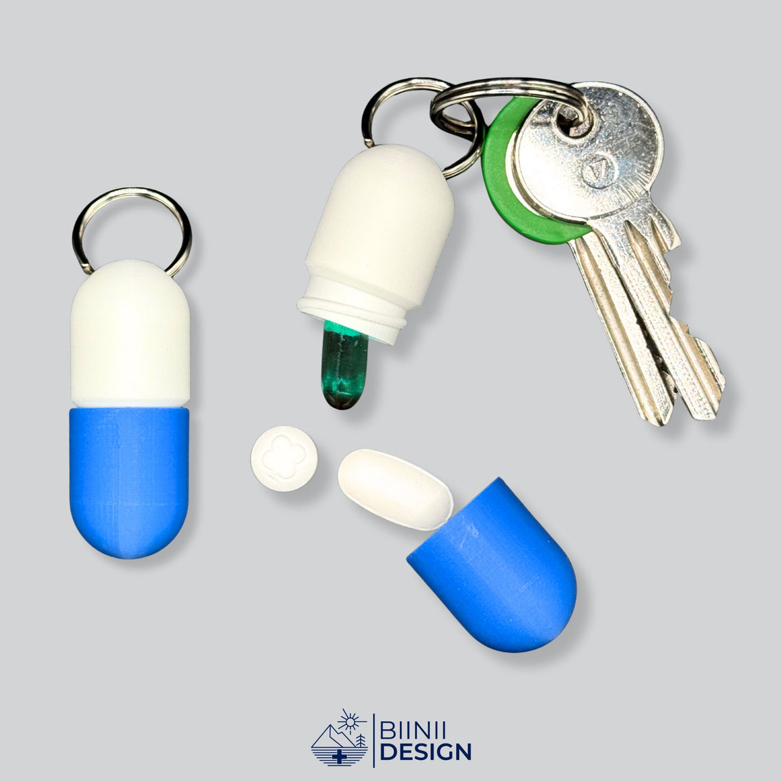 Offene weiß-blaue Large-Pillendose für den Schlüsselanhänger in Kapselform, an Schlüsseln befestigt, mit langem durchgehendem Fach.