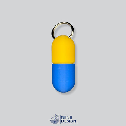 Zweifarbige Large-Pillendose für den Schlüsselanhänger, Oberteil in Gelb und Unterteil in Blau.