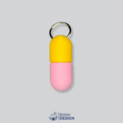 Zweifarbige Large-Pillendose für den Schlüsselanhänger, Oberteil in Gelb und Unterteil in Rosa.