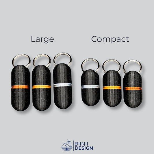 Comparison between large and compact deluxe keyring pillboxes in black galaxy finish with gold, copper, and silver rings. Sleek and practical.
Keywords: deluxe pill organizer, keychain pill case, minimalist pill holder, travel meds container, Biinii Design