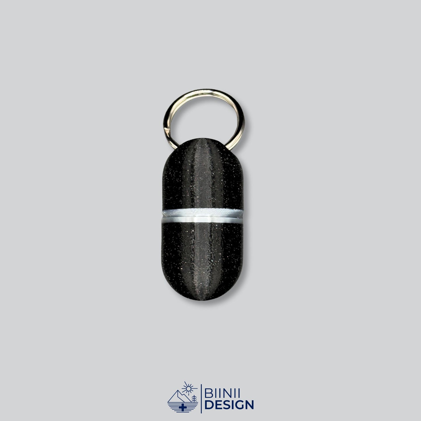 Sleek black and silver deluxe keyring pill case, designed for mobility and everyday use. Functional and discreet.
Keywords: deluxe medication container, silver pillbox, portable supplement case, Biinii Design