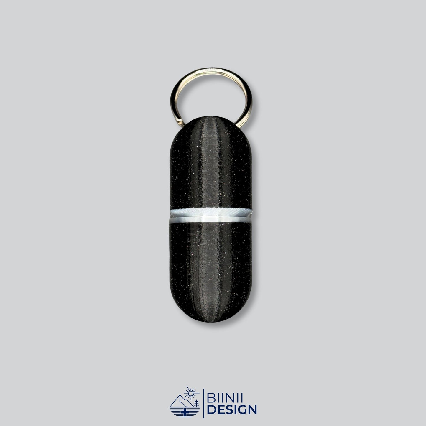 Elegant large deluxe keyring pillbox with silver band and black speckled finish. Ideal for supplements or daily pills.
Keywords: silver pill case, deluxe keychain pill holder, travel pill organizer, Biinii Design